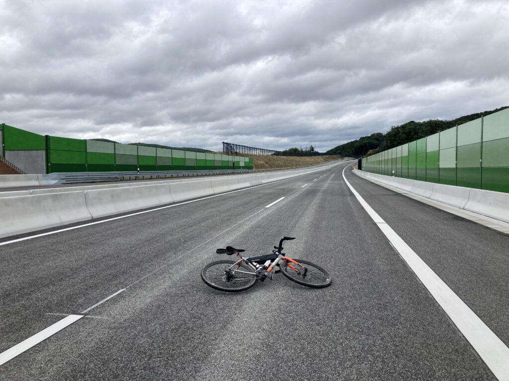 Ein Fahrrad liegt auf einer leeren Autobahn